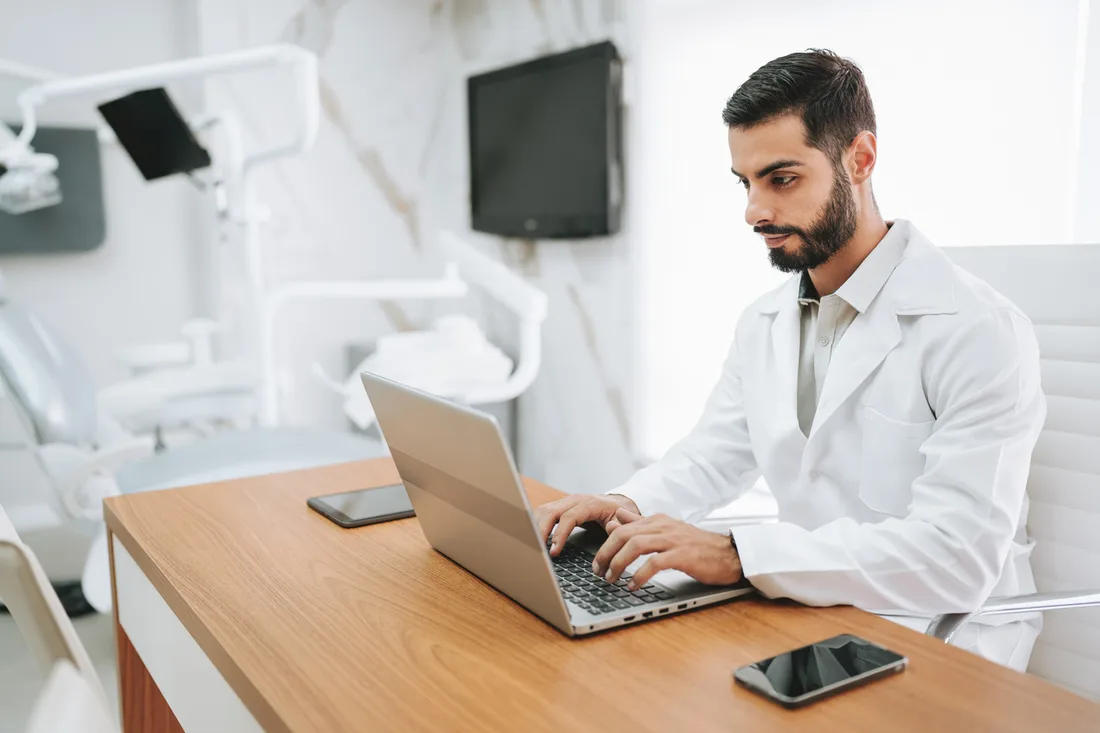 Dentista trabalhando no computador no consultório